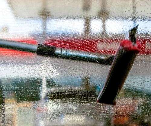 brush,  mop washing the car windshield with soapy water