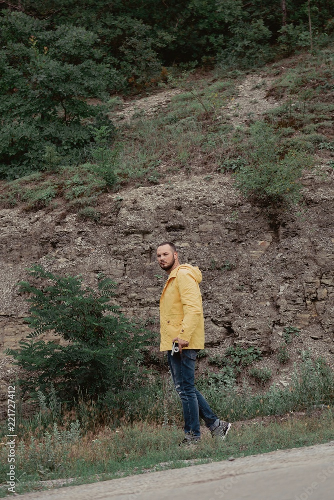 Fototapeta premium a man in a yellow raincoat with a camera