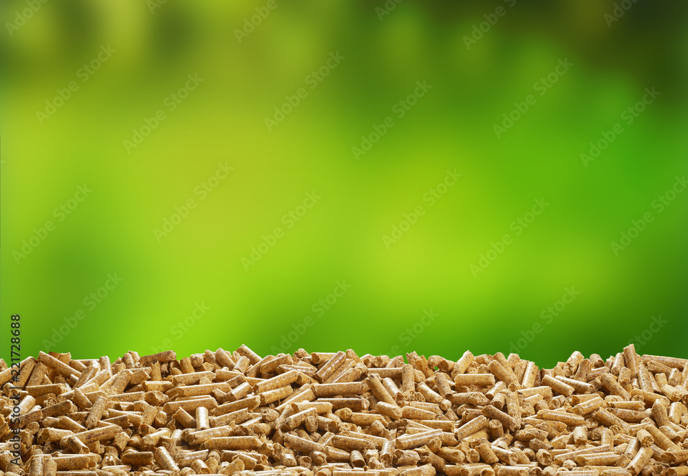 Obraz premium Organic wood pellets over green outdoor background