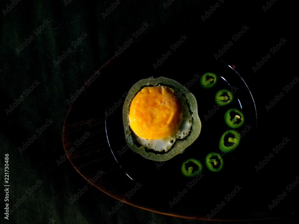 Naklejka jajka sadzone z gorzkim zielonym pieprzem na talerzu.