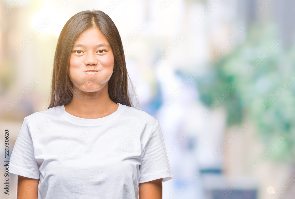 Young asian woman over isolated background puffing cheeks with funny face. Mouth inflated with air, crazy expression.