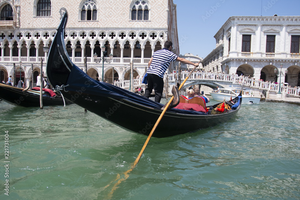 VENICE, ITALY - AUGUST 29, 2018: Traditional narrow canal street with gondolas and old houses in Venice, Italy. 