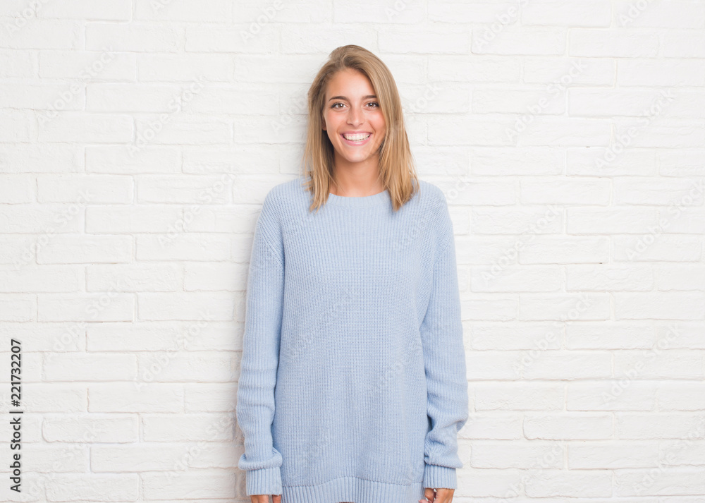 Beautiful young woman over white brick wall with a happy and cool smile on face. Lucky person. Beautiful young woman over white brick wall with a happy and cool smile on face. Lucky person.