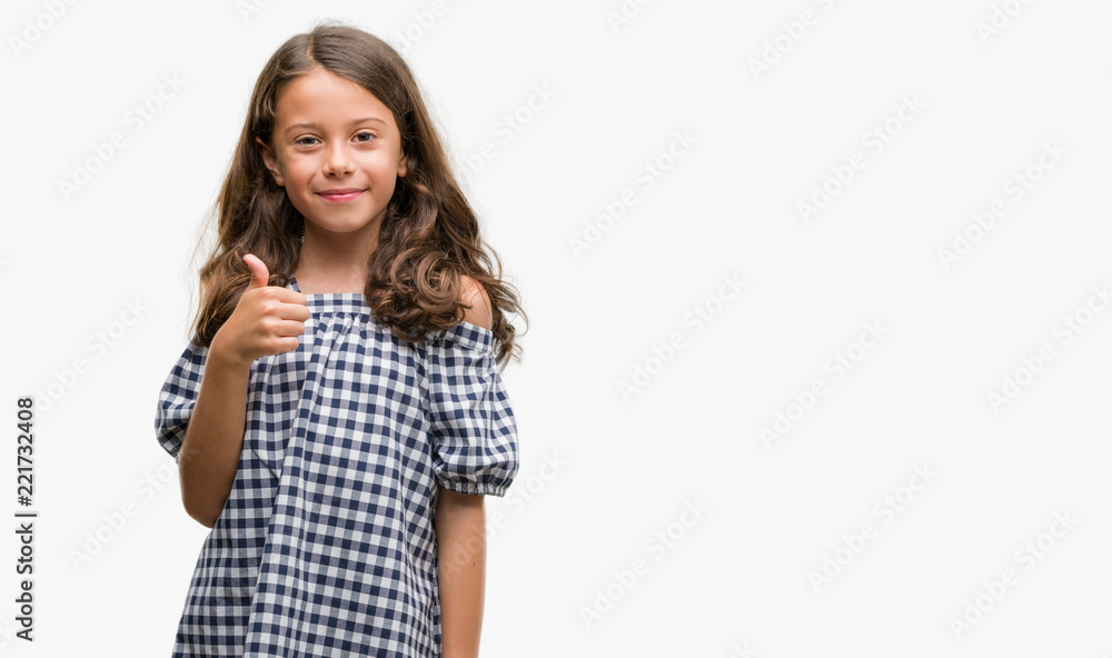 Brunette hispanic girl wearing black and white dress happy with big smile doing ok sign, thumb up with fingers, excellent sign Brunette hispanic girl wearing black and white dress happy with big smile doing ok sign, thumb up with fingers, excellent sign