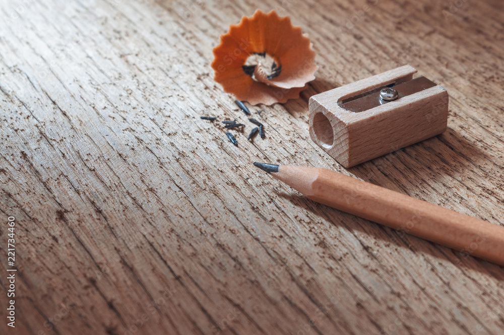 Wood pencil with sharpening shavings on old wooden texture background Wood pencil with sharpening shavings on old wooden texture background