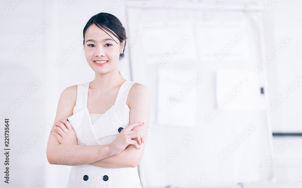Creative Design woman cross one's arm in conference room.Confident businesswoman in beautiful formalsuit on blur backgroud graph and chart on Board