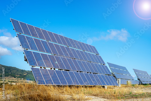 Solar farm. Solar power station with blue sky. Solar panels on the hill. Concept eco life. Concept green energy. Light spot.