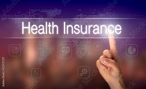 A hand selecting a Health Insurance business concept on a clear screen with a colorful blurred background.