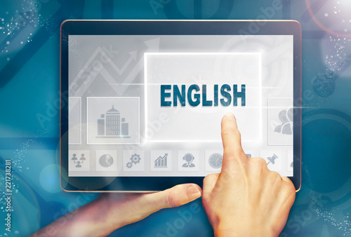 A hand selecting a English business concept on a clear screen with a colorful blurred background.