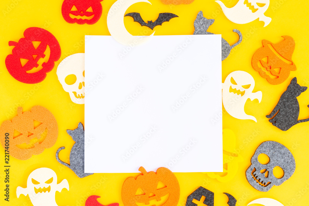 Halloween flat lay pattern on orange background with copy space on white paper note