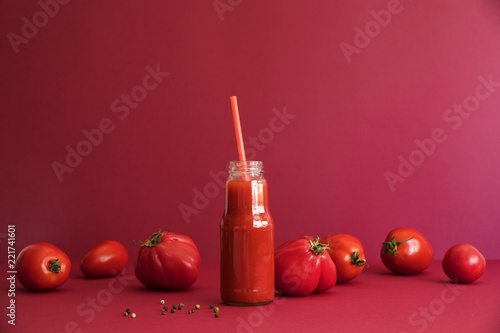 Fresh and summer tomato smoothies and tomato fruits and pepper on the red background. Many vitamins and minerals for healthy mind and body.