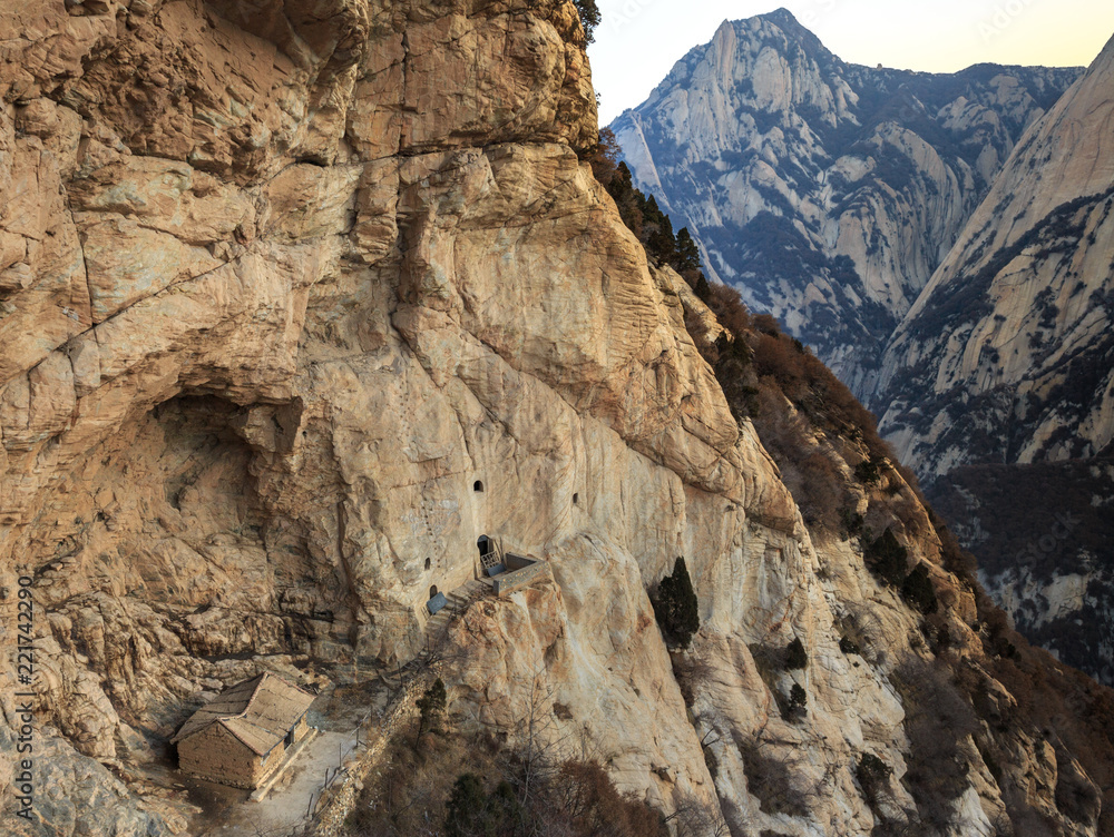 Huashan, Mount Hua - Huayin, near Xi'an in Shaanxi Province China. Cliff Scenery with Cave, Vertical Drop-off, Famous yellow granite mountains of China. Ancient House Built into the side of a mountain