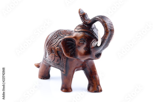 Brown Engraved pattern gold elephant made of resin like wooden carving with white ivory. Stand on white background, Isolated, Art Model Thai Crafts, For decoration Like in the spa.