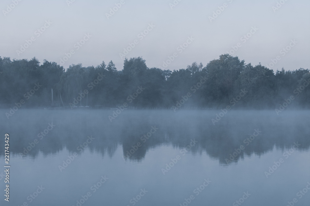 Gruseliger See mit Morgendunst im kühlen Blau. Standort: Deutschland, Nordrhein-Westfalen, Pröbstingsee