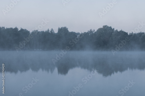 Gruseliger See mit Morgendunst im kühlen Blau. Standort: Deutschland, Nordrhein-Westfalen, Pröbstingsee