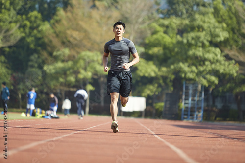 young asian male athlete running on track © imtmphoto