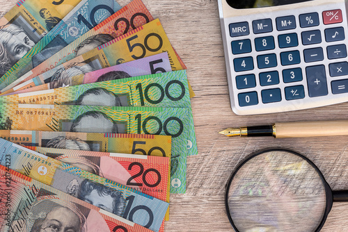 Australian dollars with calculator, pen and magnifier