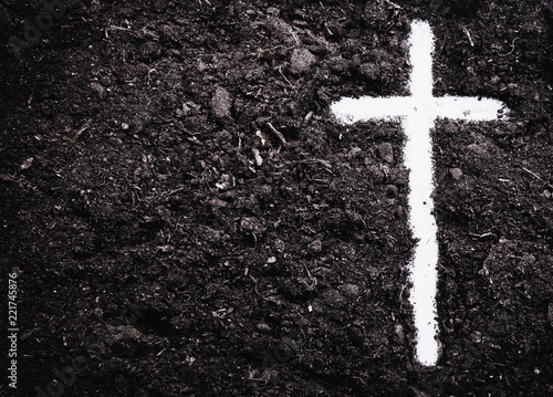 The silhouette of cross against of soil background. The cross as symbol for Jesus Christ. Christianity, religion, faith concept. photo