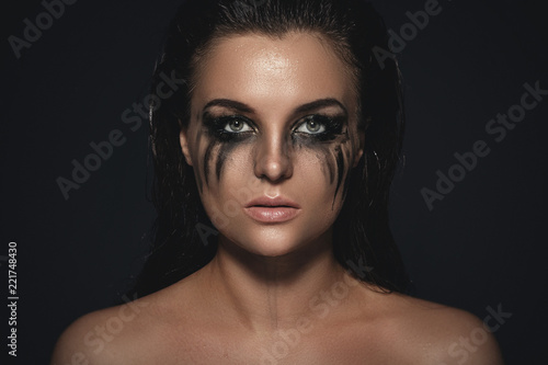 Sad and beautiful woman with smudged makeup on her face