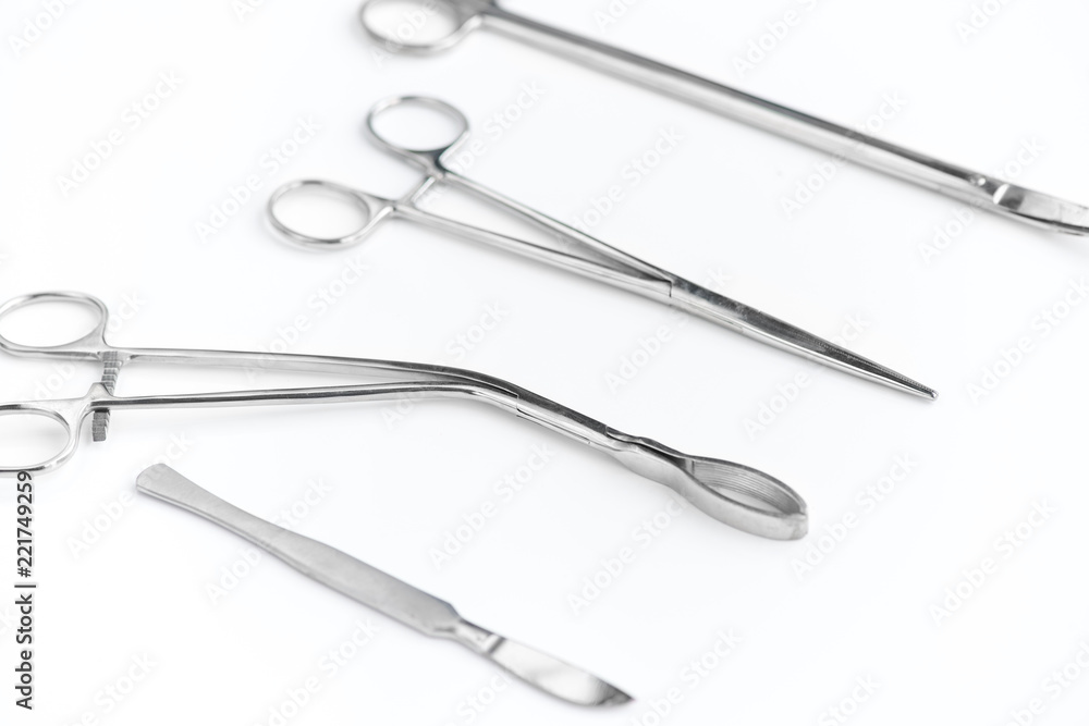 Closeup of surgical instruments in row on white background, surgical scissors, scalpel and tongs Closeup of surgical instruments in row on white background, surgical scissors, scalpel and tongs
