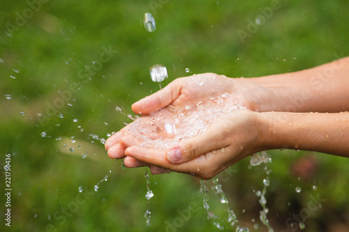 Wet female hands and clear water splashes