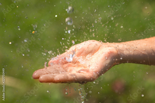 Wet female hands and clear water splashes