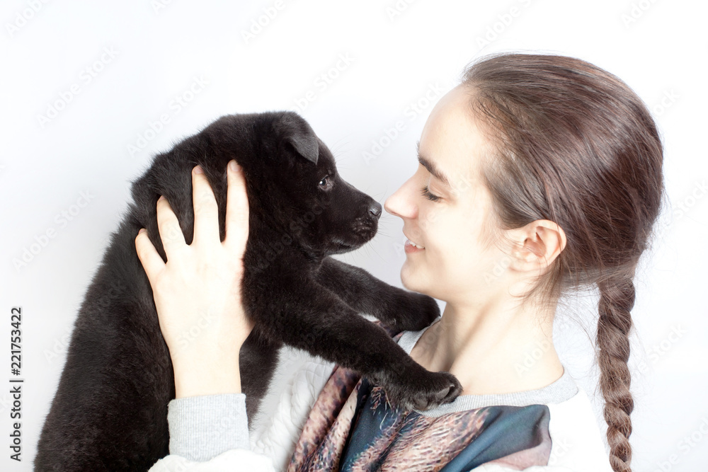 A happy teenage girl holding a German shepherd puppy in her arms A happy teenage girl holding a German shepherd puppy in her arms