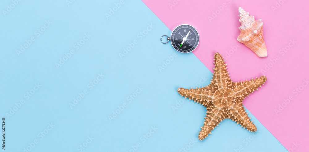 Starfish, seashell and compass on pastel colored paper texture Starfish, seashell and compass on pastel colored paper texture