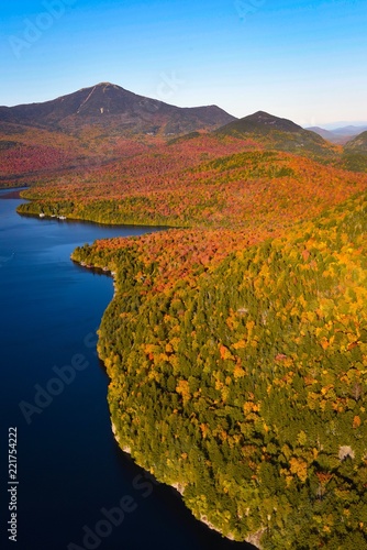 Fall colors surround a lake in New England - aerial photo