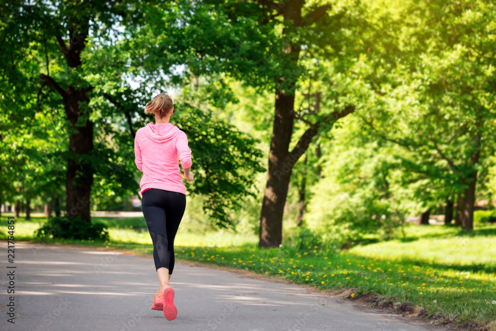 Fitness woman training and jogging in summer park