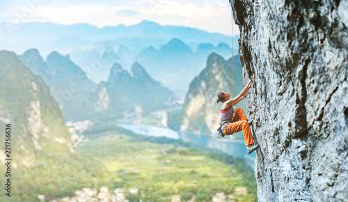 Fototapeta młoda szczupła kobieta wspinacz wspinaczka na klifie