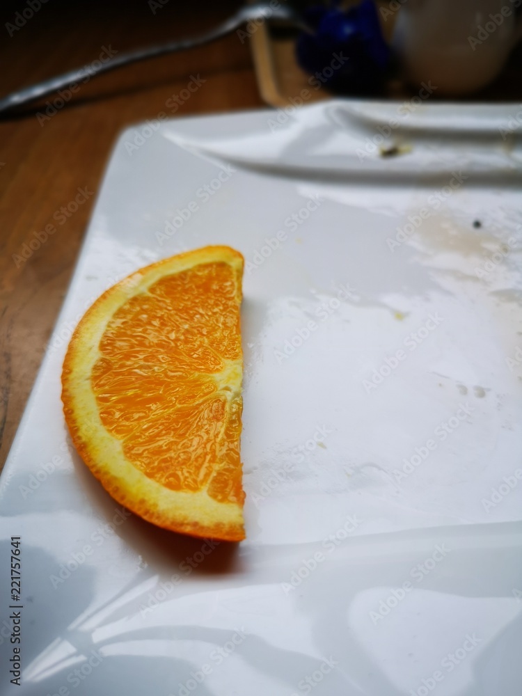 Close up orange piece on white dish Close up orange piece on white dish