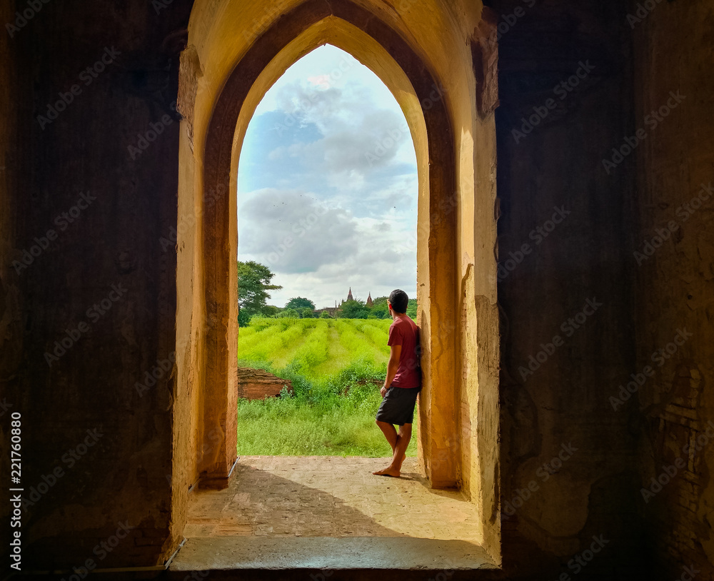 Man standing on an open arch door at Tha Gyar Pone Phay in Bagan, Myanmar