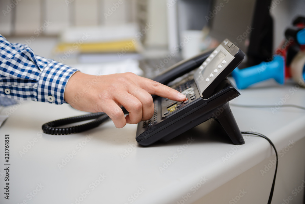 Fototapeta premium Closeup of businessman dialing making office phonecall, light table background. Corporate male holding telephone handle digital electronic pc connection checking daily data news, online chat talk job.
