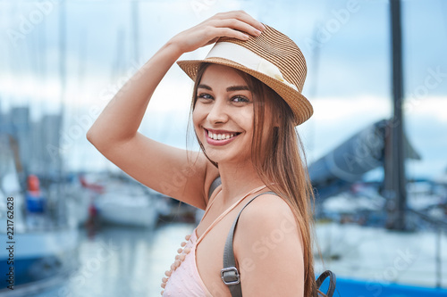 beautiful young woman travel girl on the background of a sea pier with boats and yachts, travel concept
