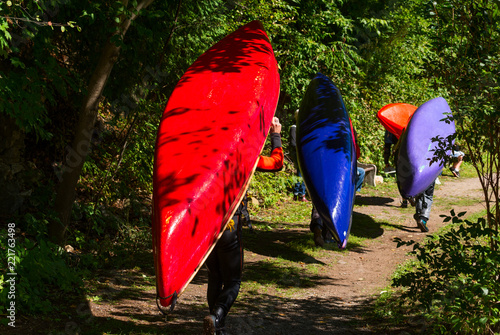 Bild auf Leinwand Group of paddlers carrying their whitewater canoes