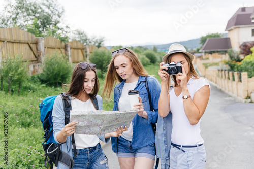 women travelling in a city using map, bags and making photos
