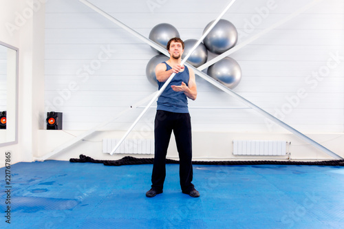 Young muscular man doing crossfit exercises in a gym