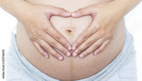 Wallpaper Mural Against the concept of abortion:Close up of woman's hands made heart on belly isolated on white background.health care concept Torontodigital.ca