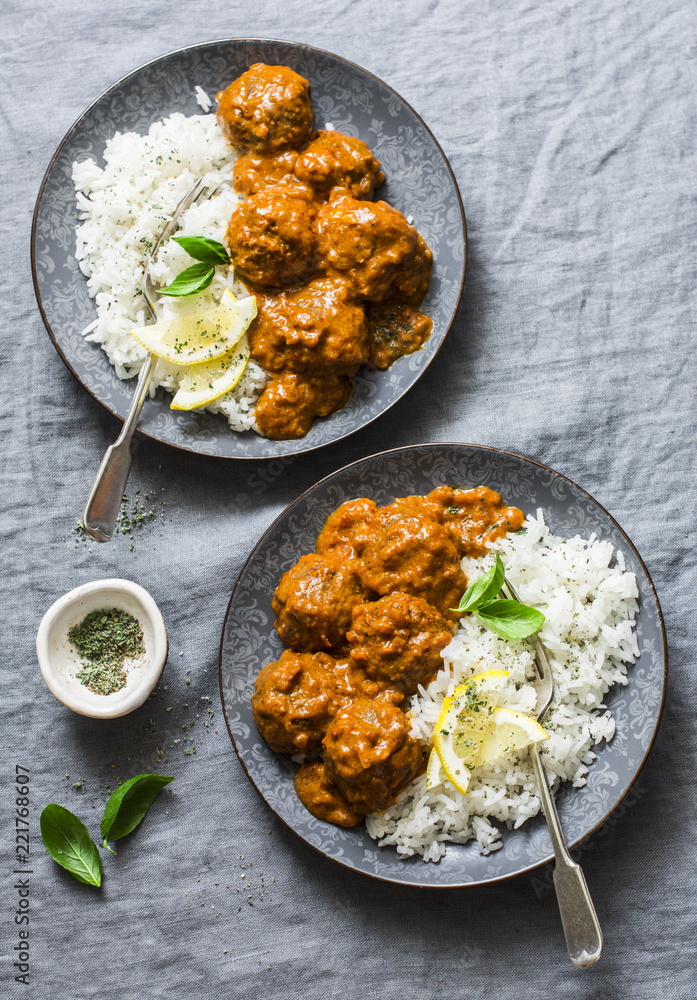 Lentils vegetarian roasted meatballs with curry sauce and rice - healthy lunch on grey background, top view. Flat lay