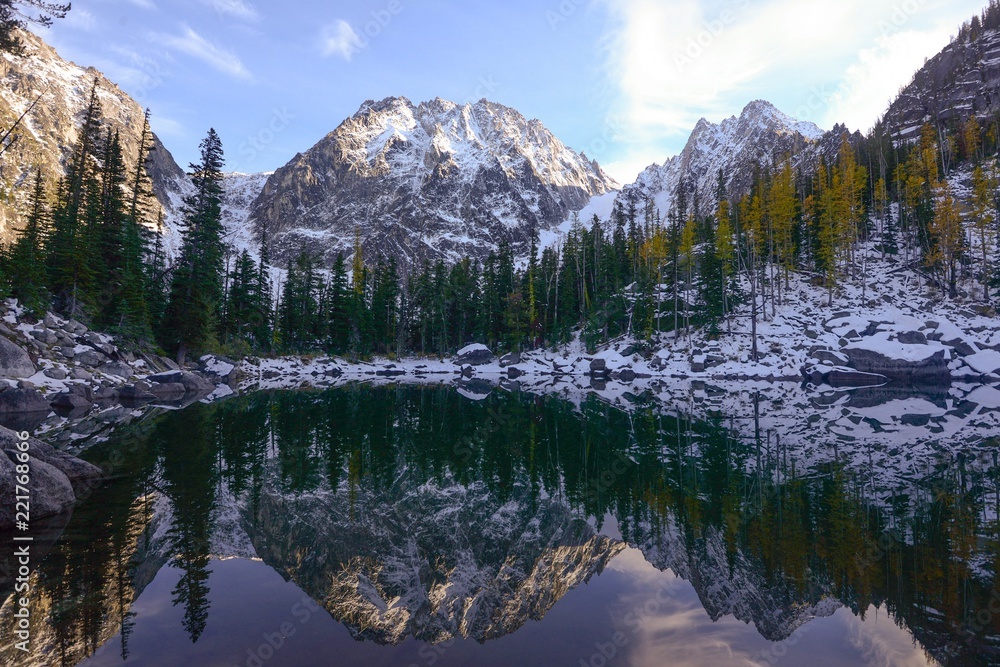 Turquoise lake and snow covered mountain reflection in autumn