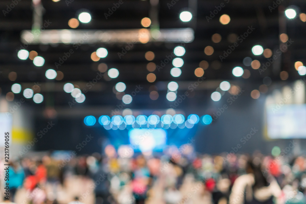 Abstract blurred photo of conference hall or seminar room in Exhibition Center with speakers on the stage and attendee background, seminar and study concept