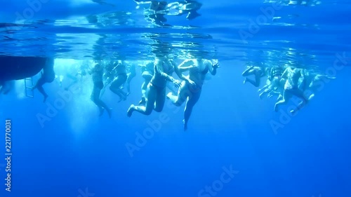 People are swimming in the open sea. View under water