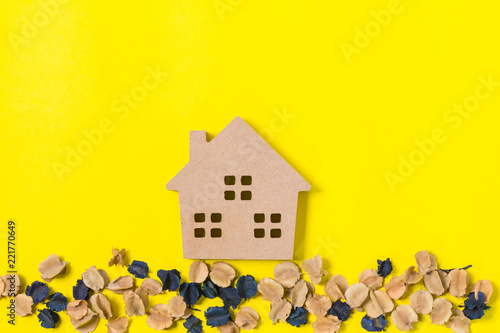 home and dried flowers on yellow background