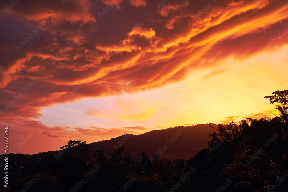 Dramatic clouds against the backdrop of mountains at sunset on a tropical island. 4k time lapse
