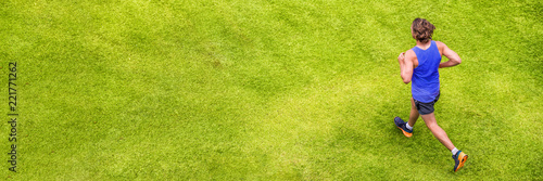 Runner man running on summer grass park jogging healthy lifestyle. People working out cardio top view. Copy space on green texture background.
