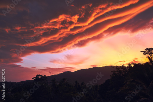 Dramatic clouds against the backdrop of mountains at sunset on a tropical island. 4k time lapse 