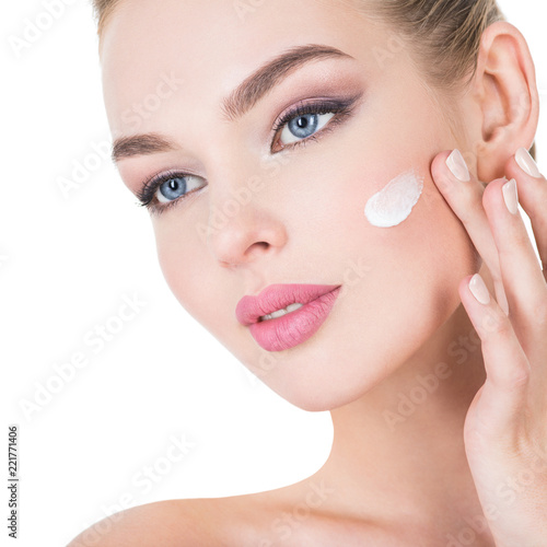 woman applies cosmetic cream on a face