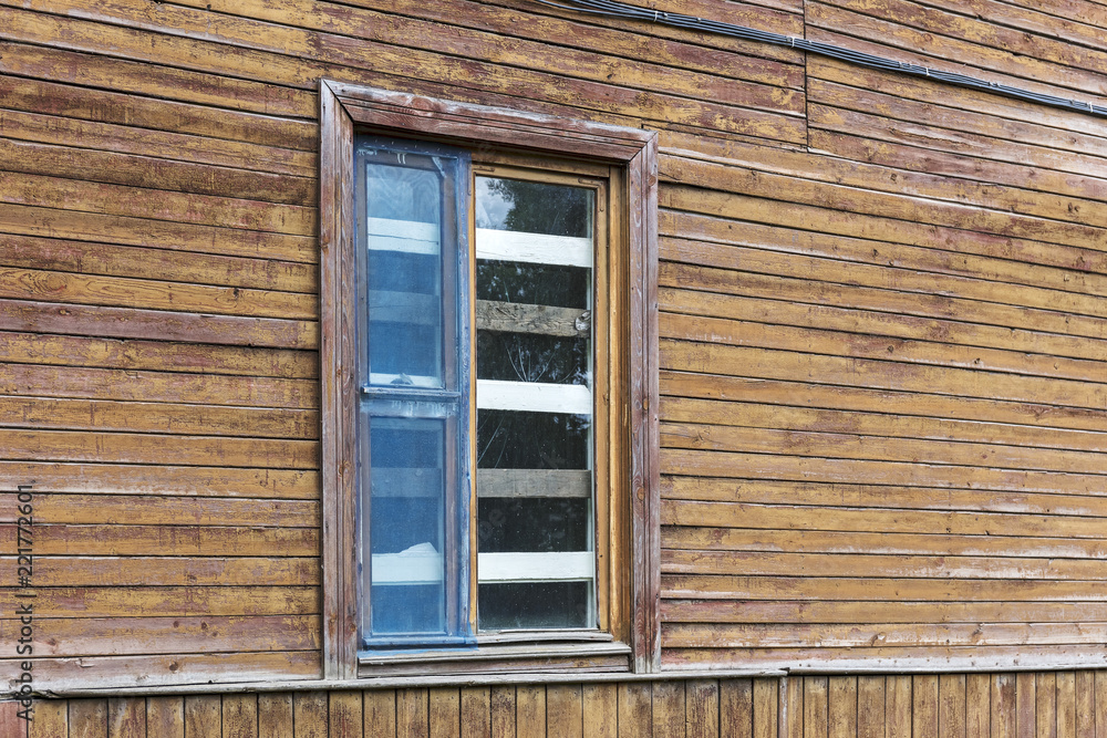 boarded up and broken window on weathered wooden wall of abandoned old house boarded up and broken window on weathered wooden wall of abandoned old house