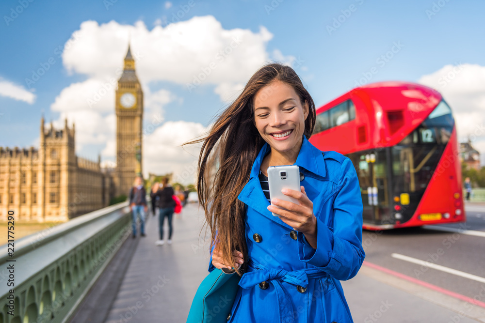 Obraz premium Londyńska kobieta biznesu wysyłająca SMS-y na aplikację mobilną na smartfona do płatności lub zakupów online. Miastowego miasta stylu życia Azjatyckiej dziewczyny szczęśliwy odprowadzenie na Big Ben i czerwonym autobusowym tle.